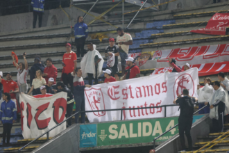 Hinchas de Internacional mostrando trapo del América de Cali